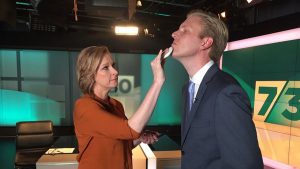 Leigh Sales puts make-up on Mark Humphries on the set of 7:30