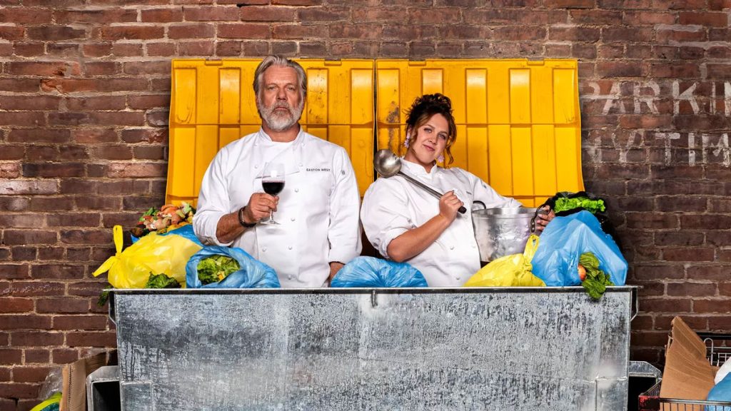 Erik Thomson and Natalie Abbott standing in a bin full of rubbish dressed in chef's whites