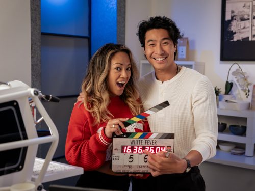 Ra Chapman and Chris Pang posing with a clapperboard