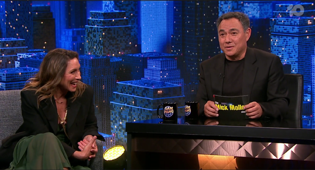 Sam Pang holds up a Mick Molloy Show cue card